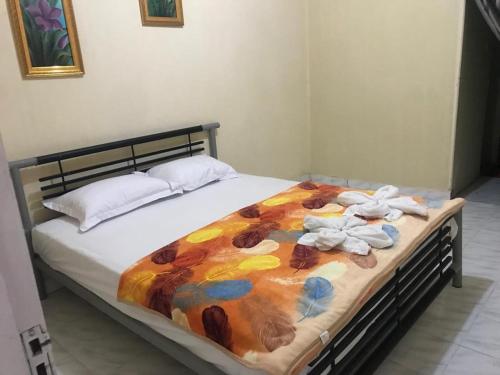 a bed with towels and stuffed animals on it at Penginapan Bunga Sonsang Padang Syariah in Tabing