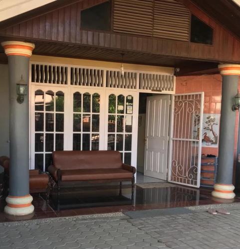 a bench sitting on the porch of a house at Penginapan Bunga Sonsang Padang Syariah in Tabing