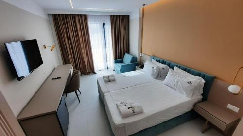 a hotel room with a bed and a flat screen tv at Delight Hotel & SPA in Golem