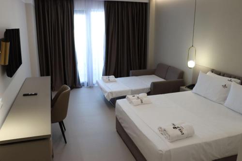 a hotel room with two beds and a couch at Delight Hotel & SPA in Golem