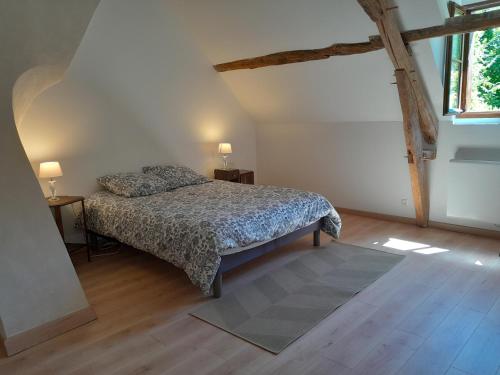 1 dormitorio con 1 cama, 2 mesas y una ventana en Ravissante longère avec grand jardin et cheminée, en Pellevoisin