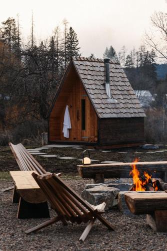 a log cabin with a fire in front of it at Apres Whitefish in Whitefish