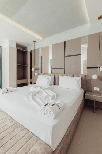 a bedroom with a large white bed with towels on it at Delight Hotel & SPA in Golem
