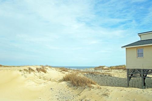 a small building on a sandy beach near the ocean at SN113- Parker in Nags Head