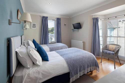 a bedroom with two beds and a window at The Artist Loft, Ensuite Guest Rooms, Porthleven in Porthleven