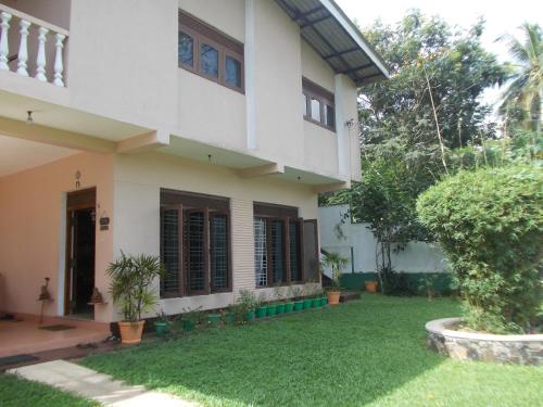 a house with a lawn in front of it at Samanala Garden Holiday Home in Hikkaduwa