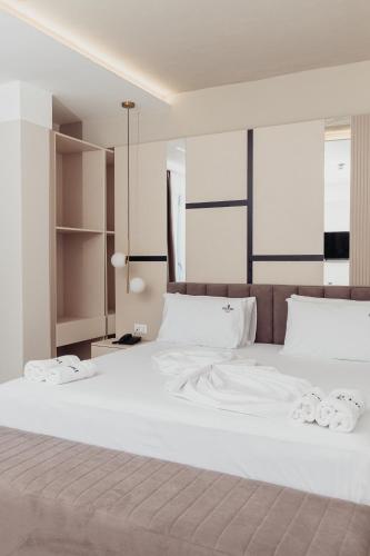 a large white bed with white sheets and pillows at Delight Hotel & SPA in Golem