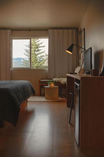 a bedroom with a bed and a desk with a television at Apres Whitefish in Whitefish
