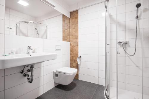 a bathroom with a toilet and a sink and a shower at Holimo Hotel in Stronie Śląskie