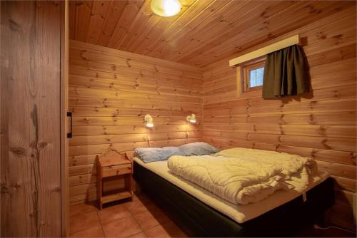 een slaapkamer met een bed in een blokhut bij Beitostølen Resort Hytter in Beitostøl