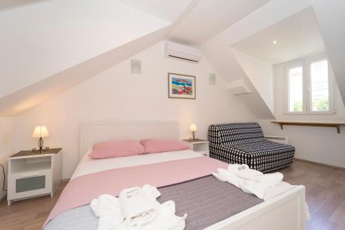 ein Schlafzimmer mit einem Bett und einem Stuhl in der Unterkunft Confluence Apartments in Korčula