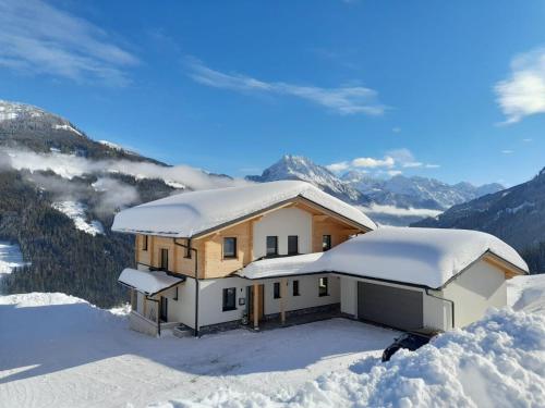 uma casa no topo de uma montanha coberta de neve em Appartement Kuschelzeit Jansenbichl em Wagrain