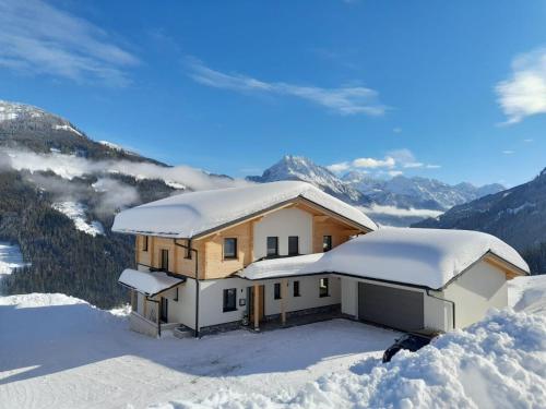 a house on top of a mountain covered in snow at Appartement Kuschelzeit Jansenbichl in Wagrain
