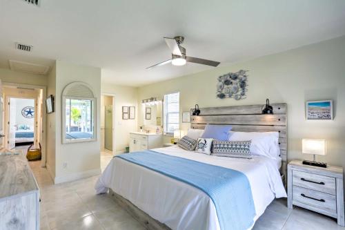 a bedroom with a large bed with a ceiling fan at Boat Owners Paradise Jensen Beach Home with Dock! in Jensen Beach