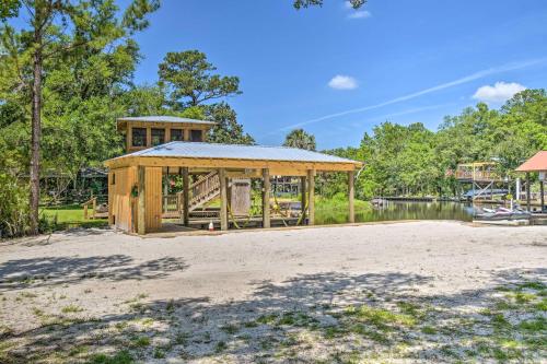 a wooden pavilion next to a body of water at Riverside New Magnolia Springs Home with Dock, Beach in Foley