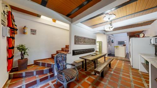 Casa Los Naranjos Hostal في ميديلين: غرفة معيشة مع طاولة وثلاجة