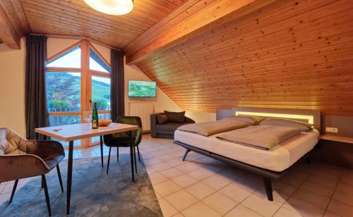 a bedroom with a bed and a table at Weingut Schumann in Lieser