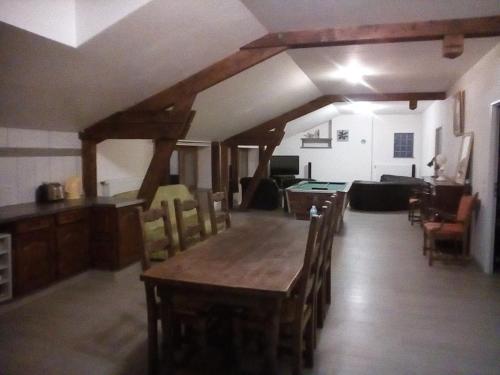 salon z drewnianym stołem i krzesłami w obiekcie Insolite! Plusieurs Gîtes dans Ferme Equestre w mieście Rehaincourt