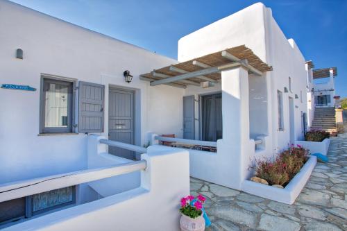 a villa with white walls and stairs with flowers at Ianthi Boutique Guesthouses Skyros in Skiros