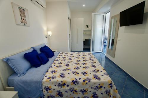 ein Schlafzimmer mit einem Bett mit blauen Kissen in der Unterkunft Relais Villa Ettore in Ischia