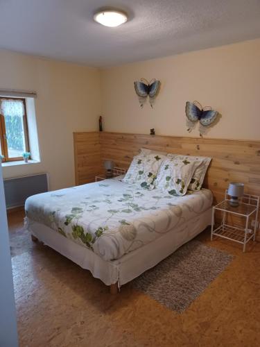 um quarto com uma cama com borboletas na parede em Gite un bout du sud em Châtel-Montagne