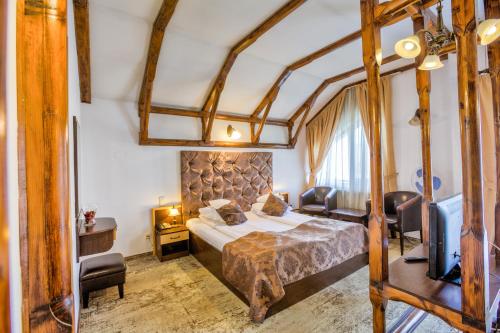 a hotel room with a bed and a television at Pensiunea Ambient in Braşov