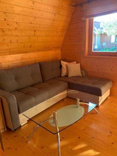 a living room with a couch and a glass table at Ośrodek Daglezja in Kołczewo