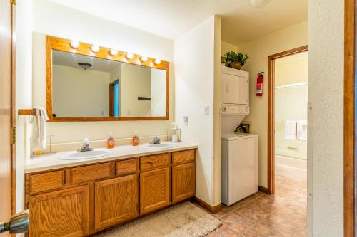 a bathroom with a sink and a mirror and a refrigerator at Altitude Adjustment in Whitefish