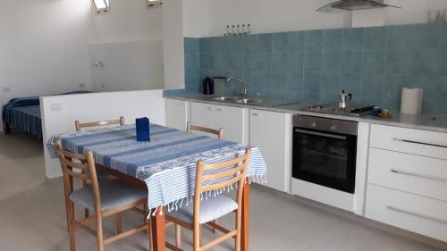 una cucina con tavolo, sedie e lavandino di mare blu a Gizzeria