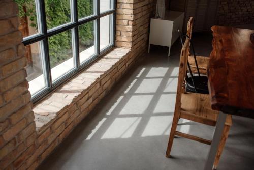 a wooden chair sitting in front of a window at Loftlakásom**** in Veszprém