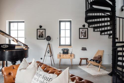 a living room with a couch and a piano at Loftlakásom**** in Veszprém
