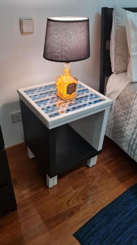 a lamp on a table next to a bed at Maligueira Apartment in Leiria