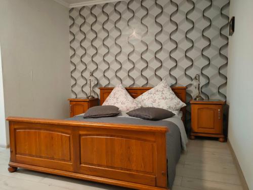 a bedroom with a wooden bed with two pillows at Pokoje gościnne Cuma in Łeba