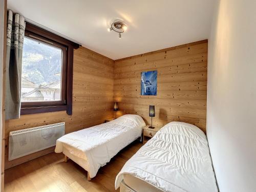 deux lits dans une chambre aux murs en bois dans l'établissement T3 centre Chamonix, parking, WiFi, 4-6 pers - FR-1-507-3, à Chamonix-Mont-Blanc