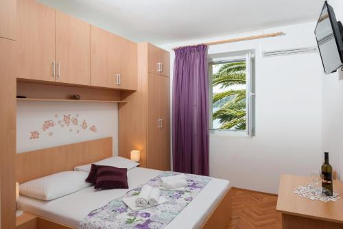 um pequeno quarto com uma cama e uma janela em Guesthouse Pavla em Goveđari