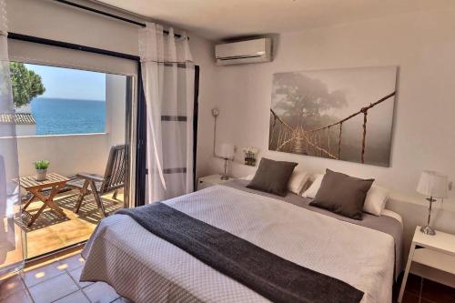 a bedroom with a bed and a view of the ocean at Donalolaplaya in Mijas Costa
