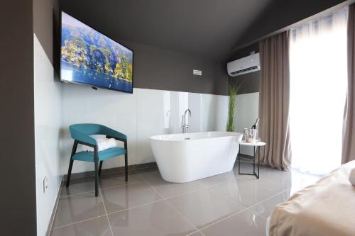 a bathroom with a tub and a tv on the wall at 9 apartments in Jagodina