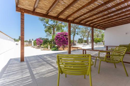 a patio with chairs and a table and a wooden roof at B&B Villa Massimo in Porto Cesareo