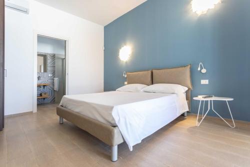 a bedroom with a large bed and a blue wall at B&B Villa Massimo in Porto Cesareo