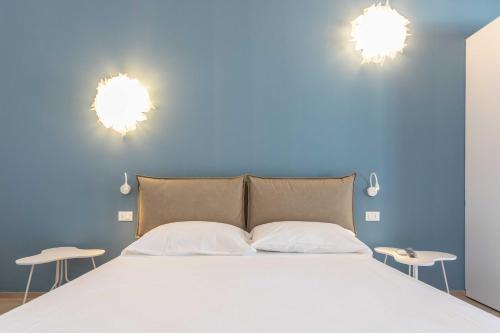 a bedroom with a bed with blue walls and two chairs at B&B Villa Massimo in Porto Cesareo