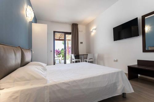 a bedroom with a bed and a television and a table at B&B Villa Massimo in Porto Cesareo