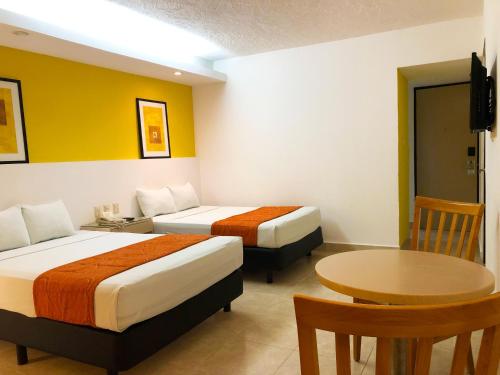 Un pat sau paturi într-o cameră la Hotel Los Cocos Chetumal