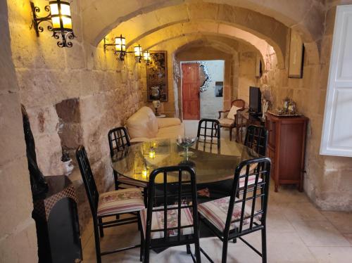 Unique House of Character in centre of Mosta في موستا: غرفة طعام مع طاولة وكراسي