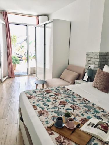 a bedroom with a bed with a book and cups on it at Apartamentos Élite - Art Collection - Frida in Mérida