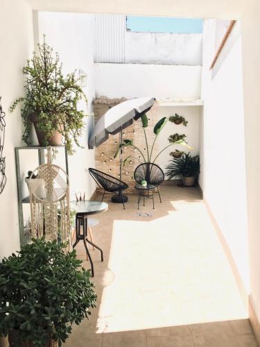 a patio with chairs and an umbrella and plants at Apartamentos Élite - Art Collection - Frida in Mérida