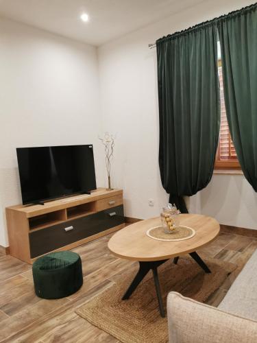 a living room with a tv and a coffee table at Apartmani Tripalo in Imotski
