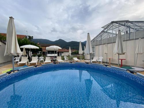 a large swimming pool with chairs and umbrellas at Casa Sanfè in Albenga