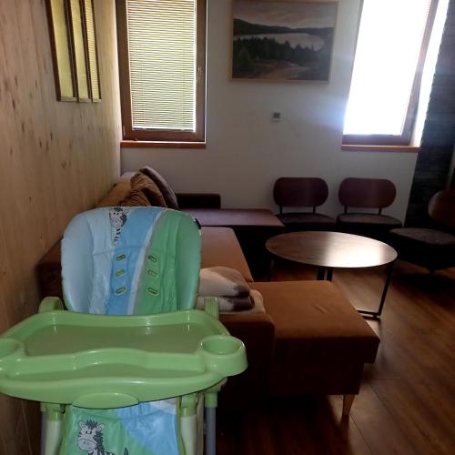 a living room with a chair and a table at Apartmany Milano s výrivkou a terasou in Kvakovce