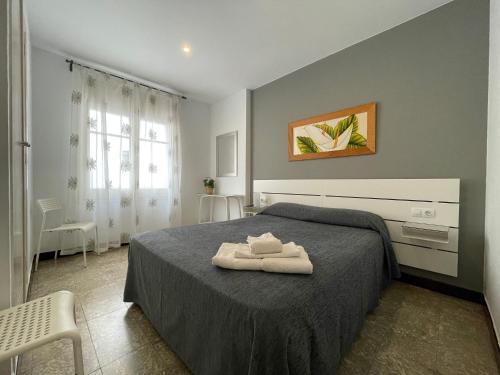 a bedroom with a bed with two towels on it at Hostal Mediterráneo in Tossa de Mar