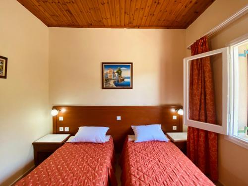 a hotel room with two beds and a window at Beach House in Lefkimmi